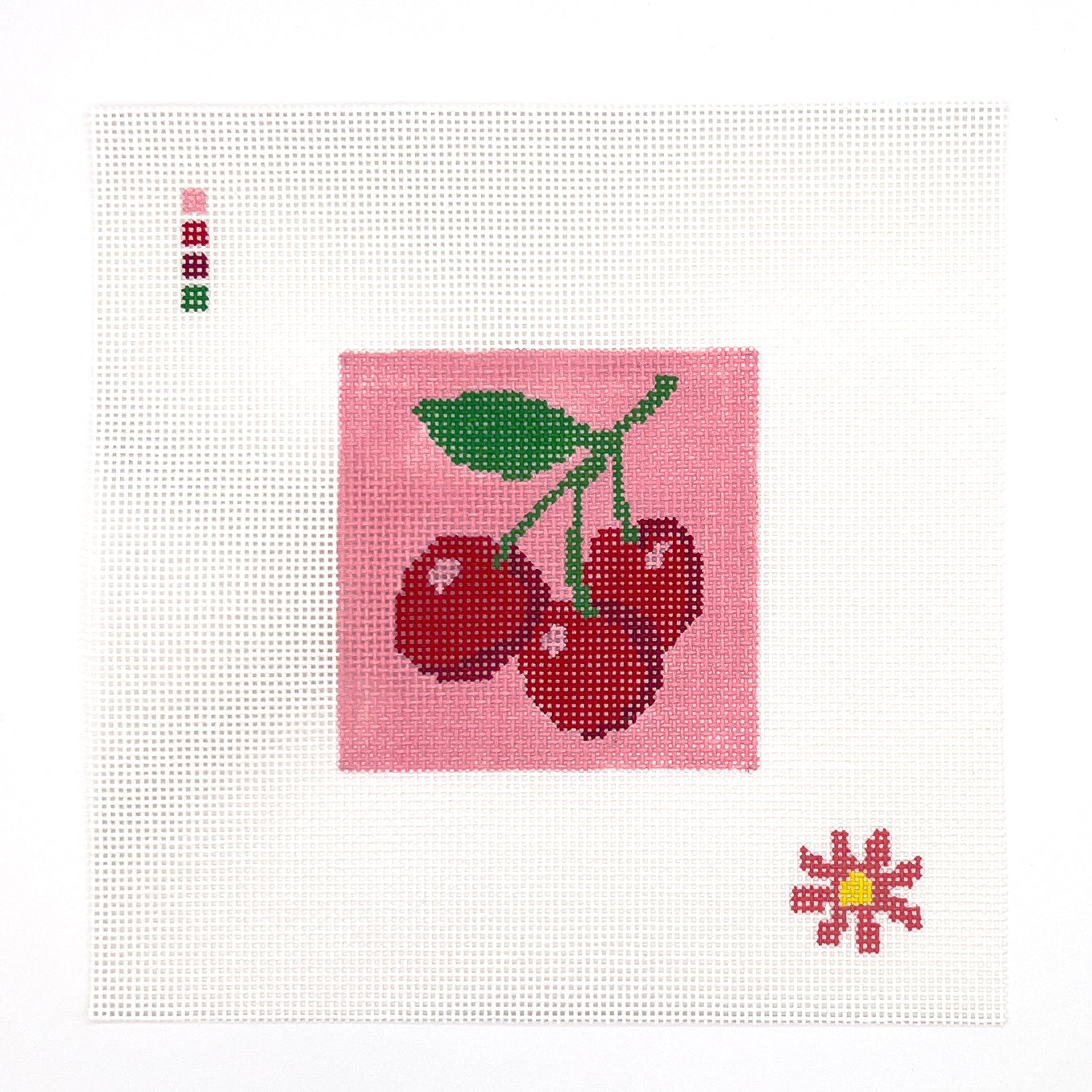 The image is a digital illustration featuring a pink square with a green leaf and three red cherries. There is also a small pink flower in the bottom right corner of the image.